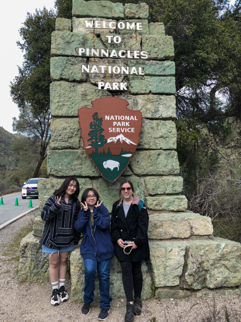 Author and two cousins posing in front of the welcome sign to Pinnacles National Park