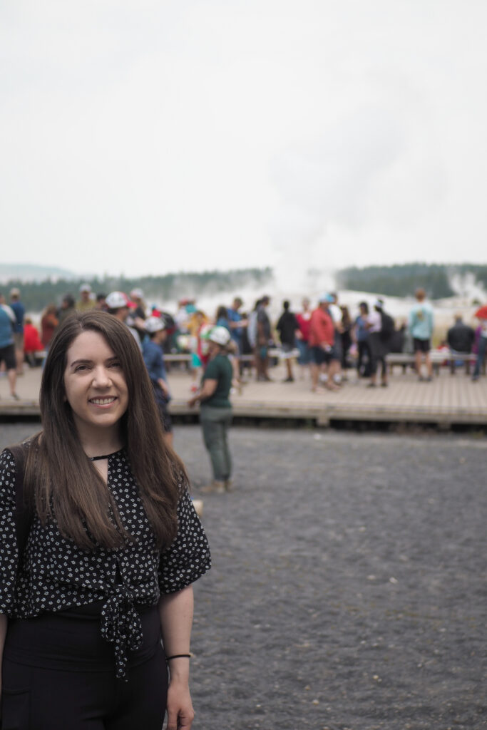 author in front of Old Faithful at Yellowstone National Park