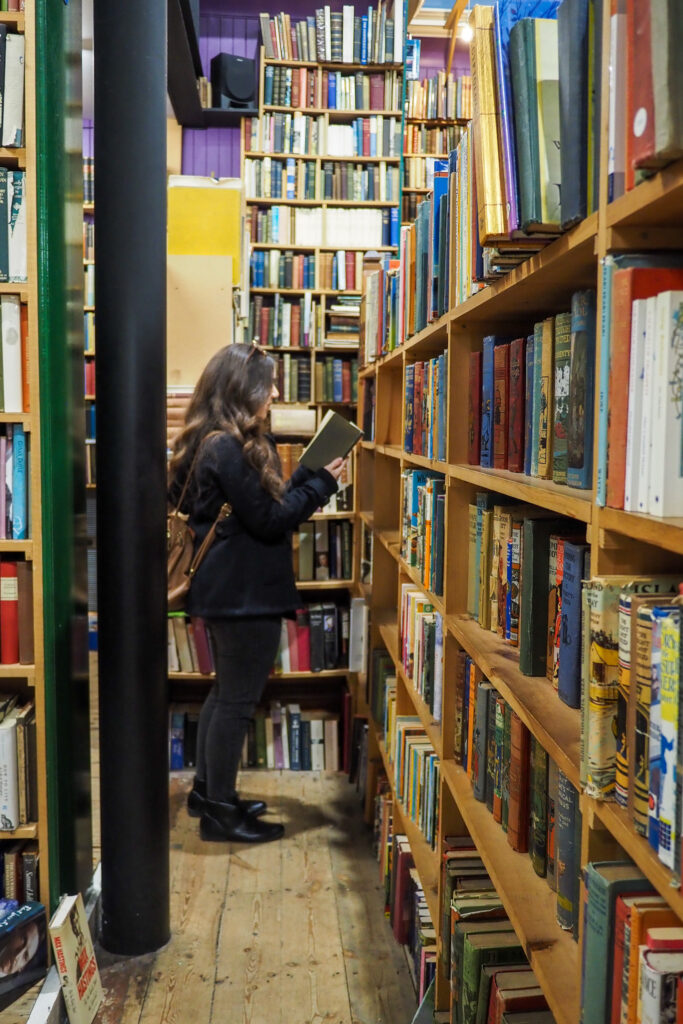 Author, a young woman, reading a book in Leakey's Bookshop in Inverness, Scotland
