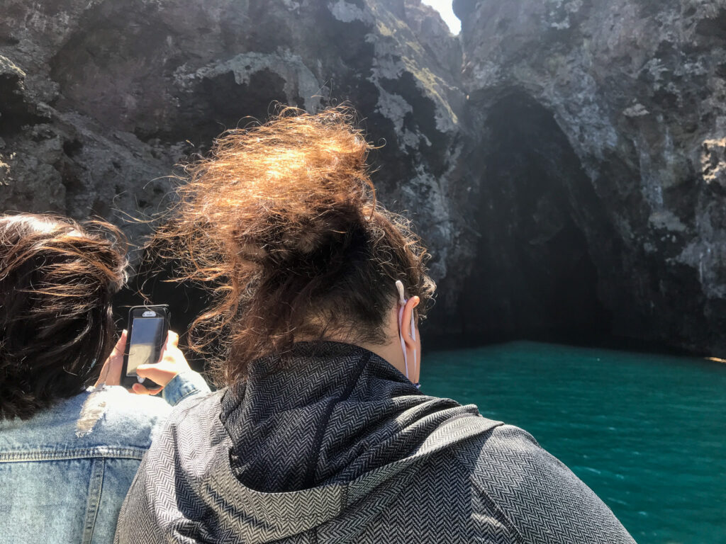 Author's two family members taking photos at the entrance to the Painted Cave on Santa Cruz Island in Channel Islands National Park