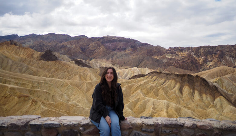 author sitting on a wall at zabriskie point in death valley