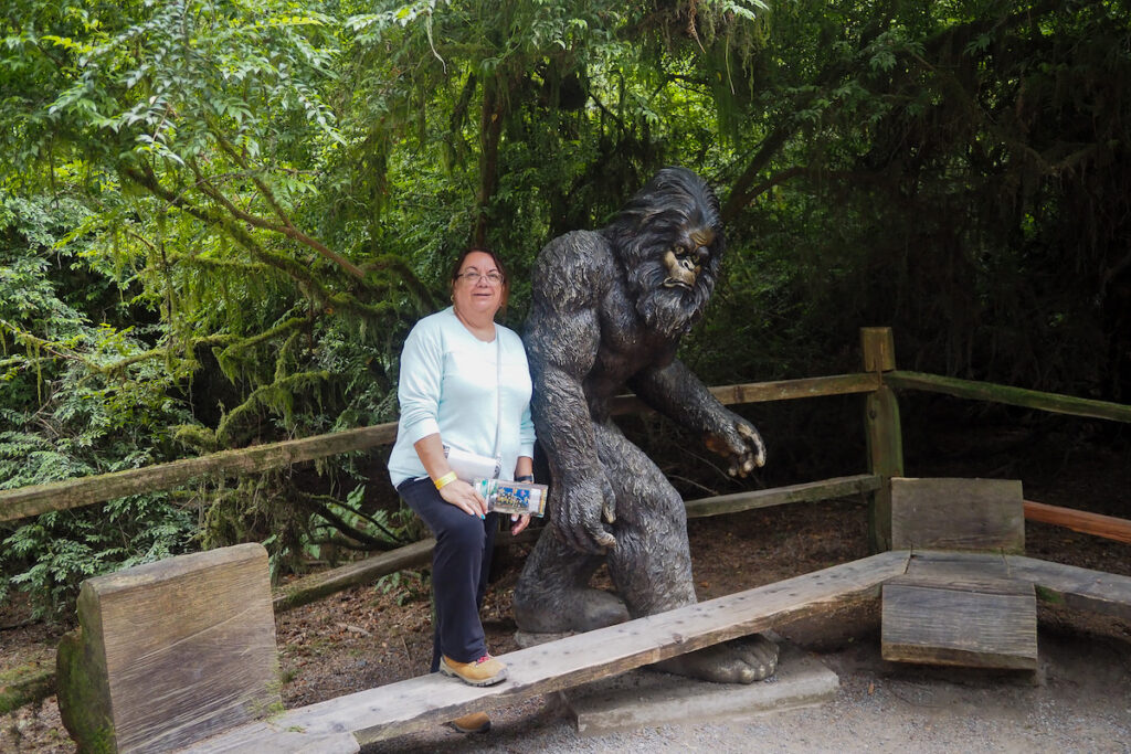 author's mom standing next to a bigfoot statue in mystery of trees, klamath