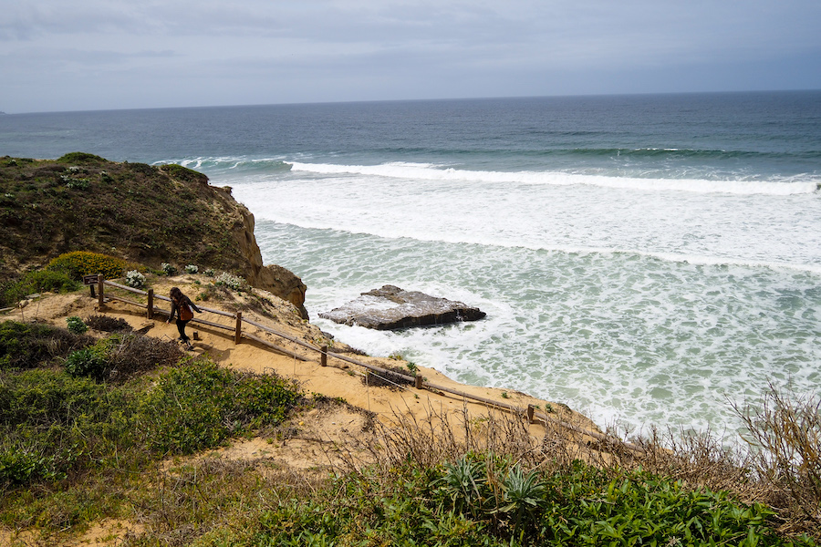 girl walking along a trail by the ocean