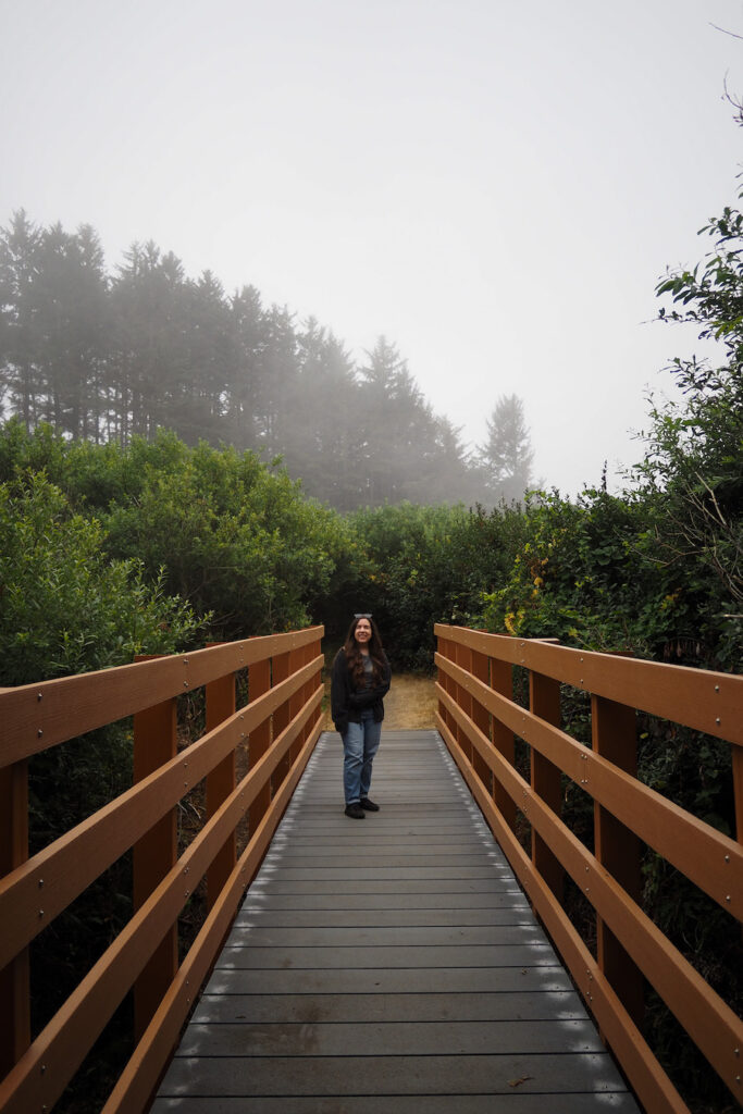 author on a bridge with trees in the background