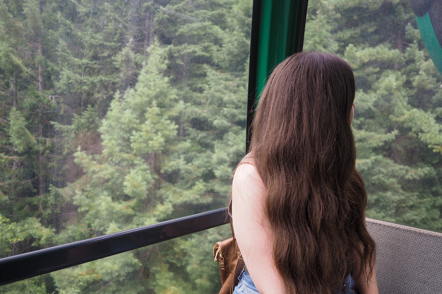 author riding the skytrail gondola high into the trees