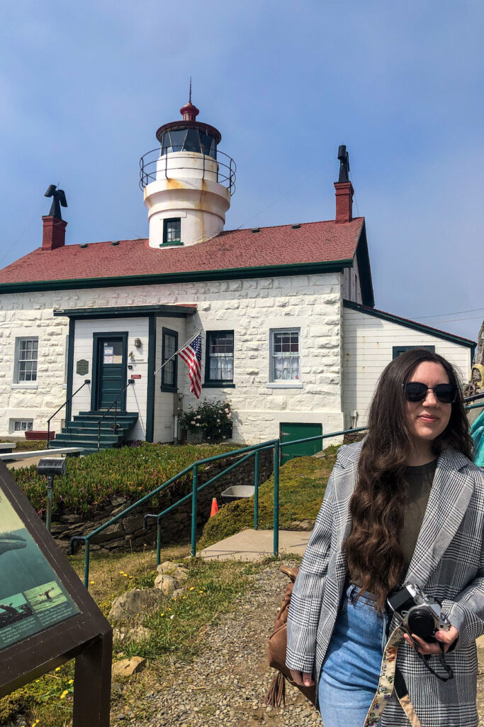 girl standing in front of a lighthouse