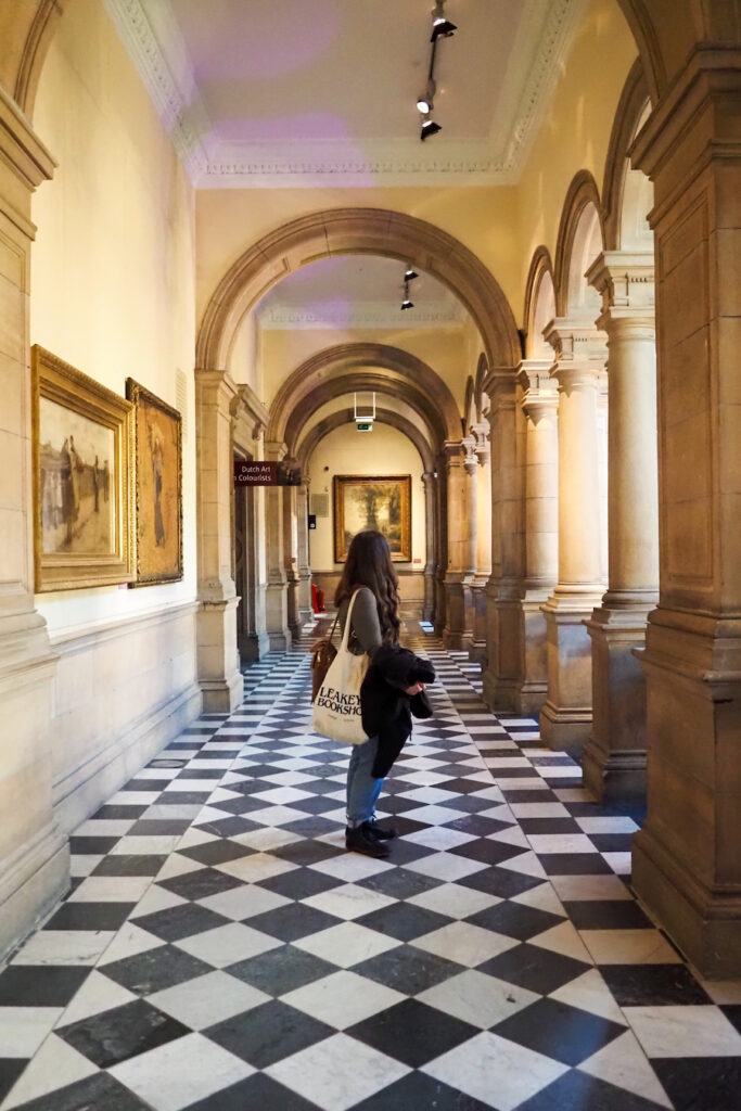 girl standing in a museum with checkered floor.