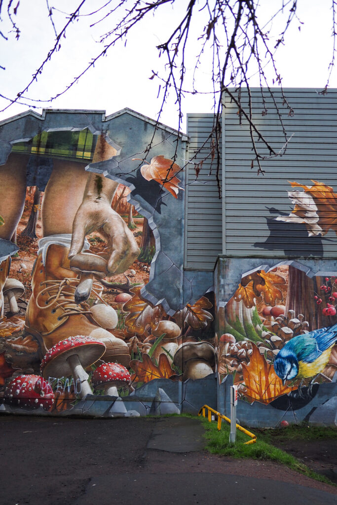 part of the Fellow Glasgow Residents mural, featuring a kilted man picking up a mushroom on the forest floor