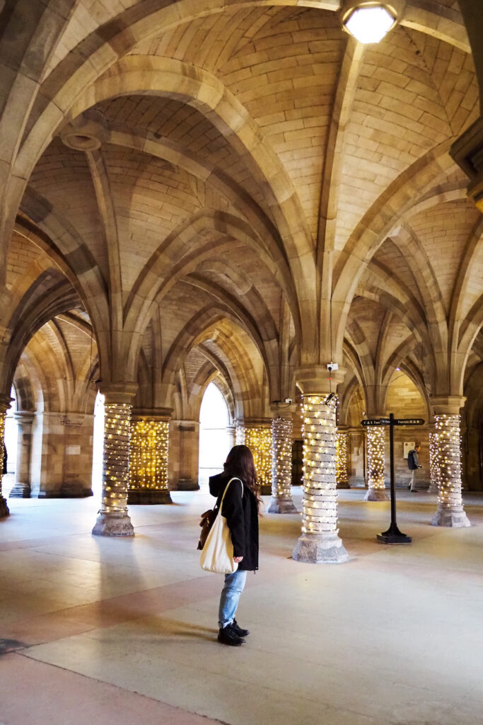the author, a young woman, standing in the middle of the Cloisters in the University of Glasgow