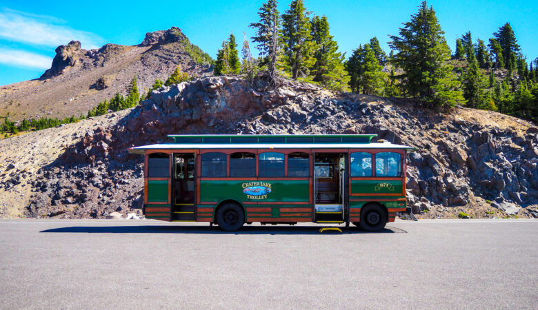 the crater lake trolley on the road with trees behind it