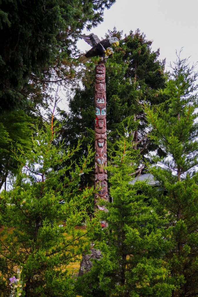 a tall totem pole in the midst of trees
