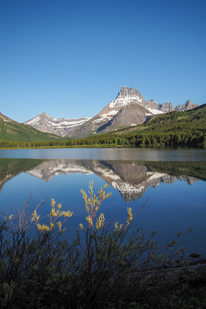 the mountains reflecting on the still lake in Glacier National Park