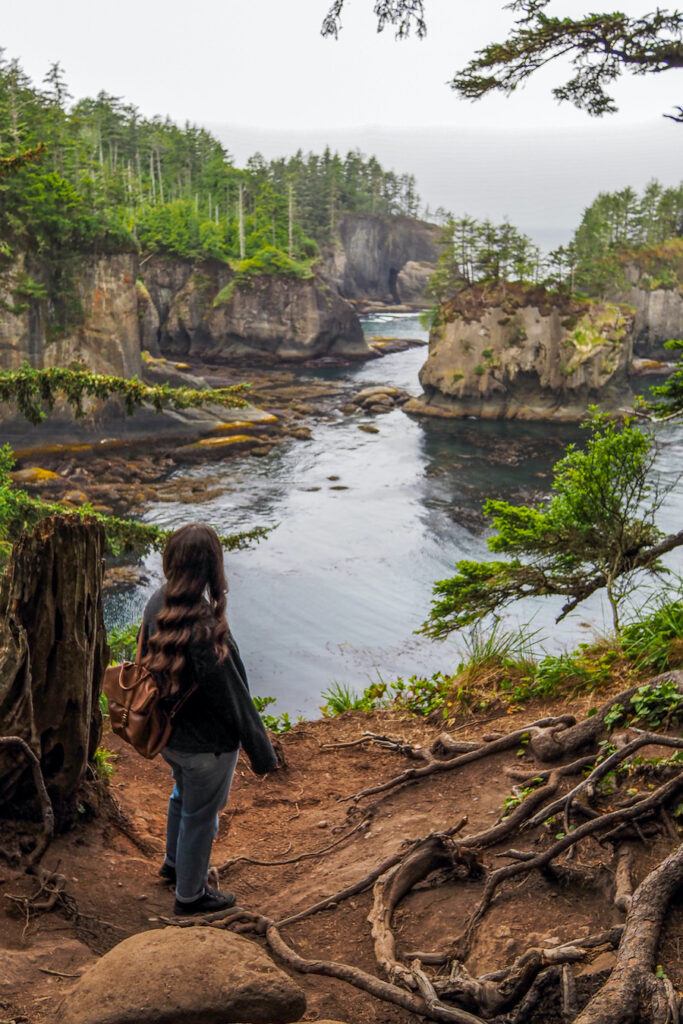 girl standing near a cliff edge looking at the view of islands in the ocean