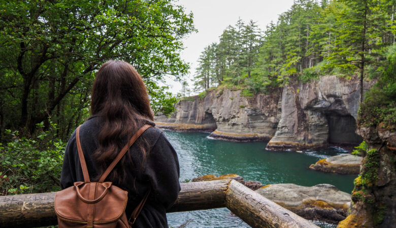 girl looking out at views of sea caves in olympic peninsula