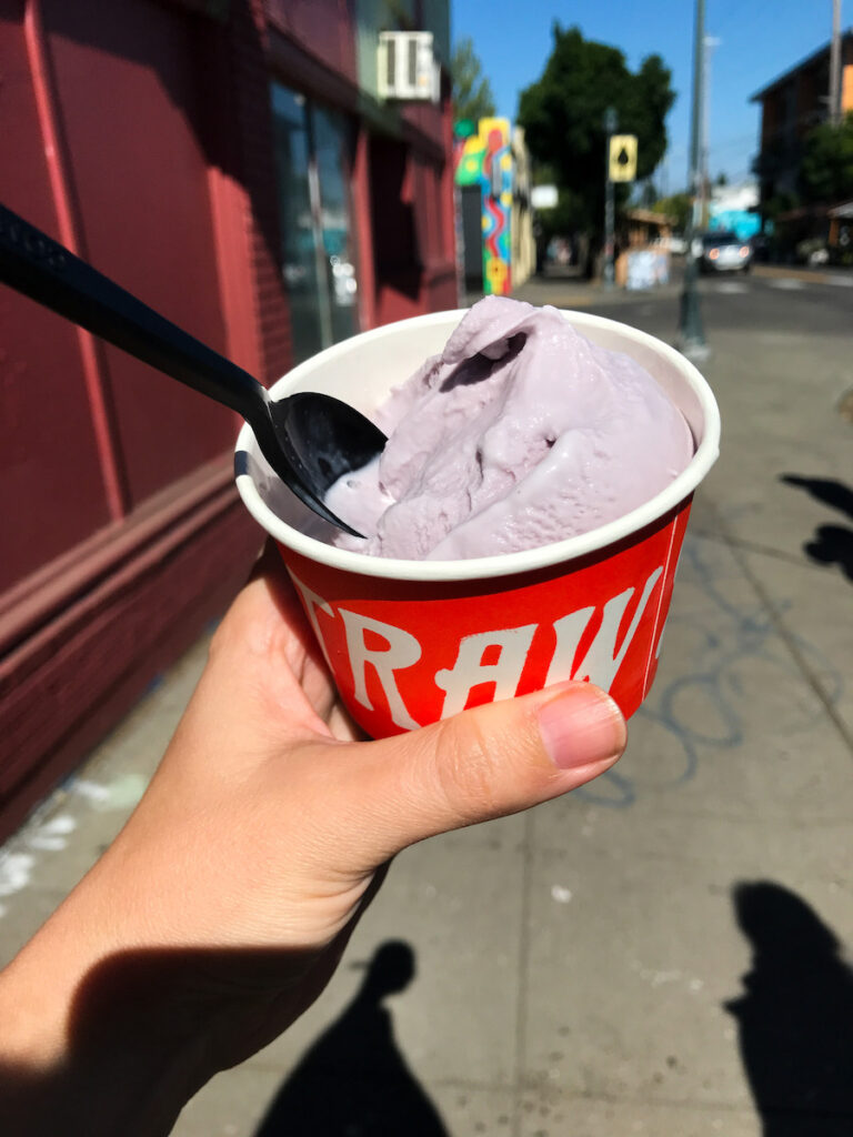 someone holding an ice cream cup that says "Salt and Straw" with lavender ice cream inside