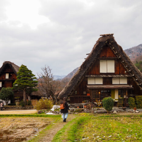 girl standing in front of traditional japanese houses in shirakawago japan