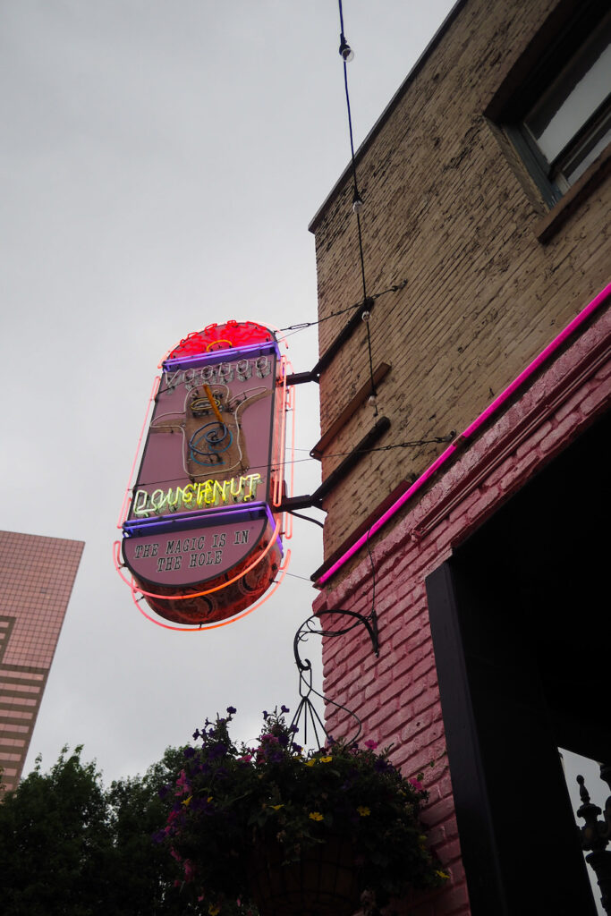 a sign that says "Voodoo Doughnut" on a storefront in Portland