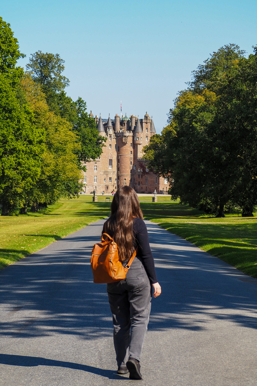 young woman walking toward Glamis Castle