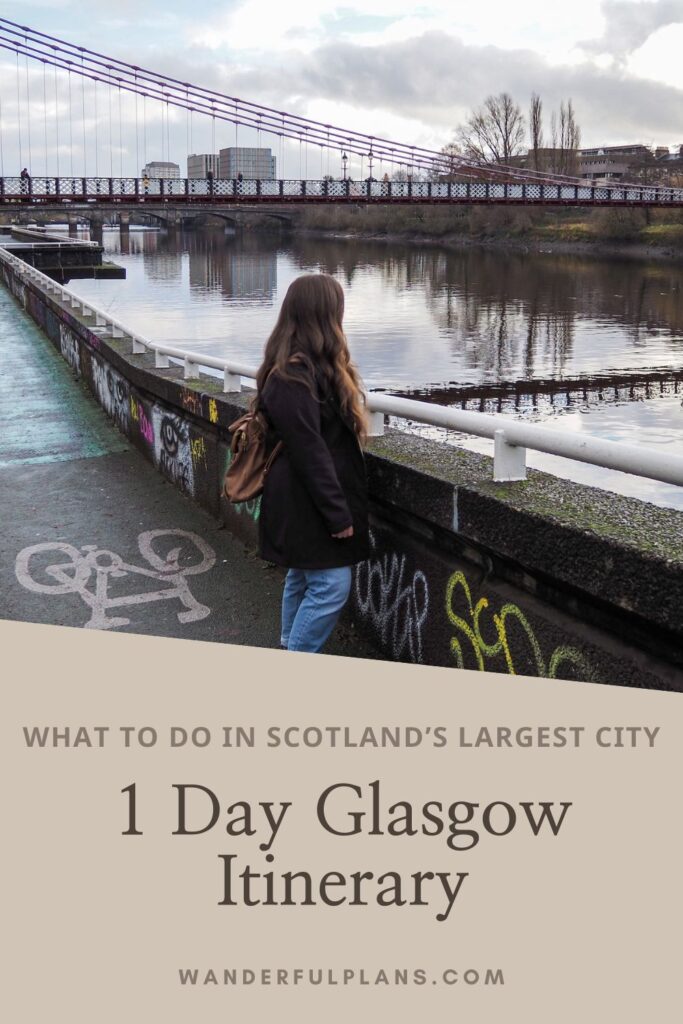 A woman with long brown hair stands on a graffiti-covered bridge in Glasgow, looking at the river and a distant suspension bridge. Text below reads: “1 Day Glasgow Itinerary – What to do in Scotland’s largest city.”.