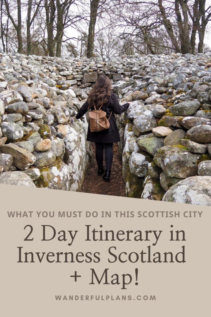 A woman with long brown hair, wearing a black coat and brown backpack, walks between ancient stone walls. Text overlay reads: 2 Day Itinerary in Inverness Scotland + Map! wanderfulplans.com.